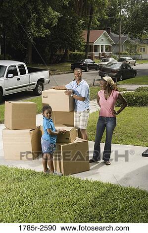 Portrait of a family standing with cartons in driveway View Large Photo Image Stock Image - Portrait of a family standing with cartons in driveway. Fotosearch