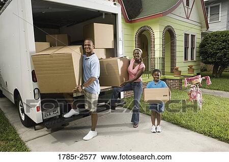 Stock Photo - Portrait of a family unloading boxes from moving truck. Fotosearch