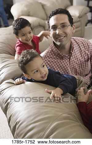 Portrait of a father with sons on a sofa View Large Photo Image Stock Image - Portrait of a father with sons on a sofa. Fotosearch