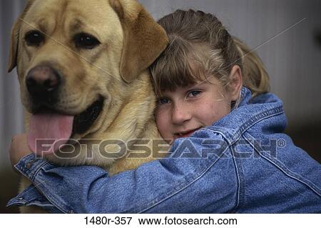 Stock Photo - Portrait of a girl hugging her dog. Fotosearch