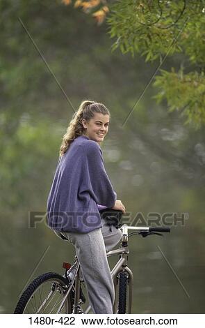 Stock Image - Portrait of a girl sitting on a bicycle. Fotosearch