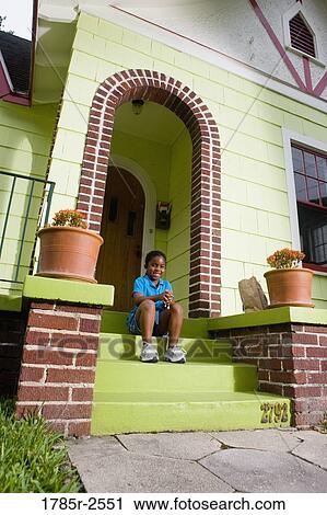 Portrait of a girl sitting on front steps of house View Large Photo Image Stock Image - Portrait of a girl sitting on front steps of house. Fotosearch