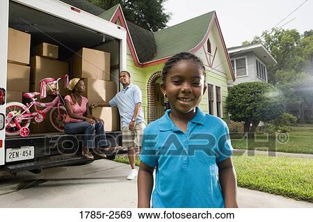 Portrait of a girl standing in front of parents and moving truck View Large Photo Image Stock Photo - Portrait of a girl standing in front of parents and moving truck. Fotosearch