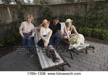 Stock Photo - Portrait of a happy American family on deck chairs. Fotosearch