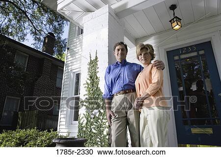 Portrait of a mature couple standing outside a house View Large Photo Image Stock Image - Portrait of a mature couple standing outside a house. Fotosearch