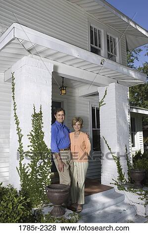 Portrait of a mature couple standing outside a house View Large Photo Image Stock Photo - Portrait of a mature couple standing outside a house. Fotosearch