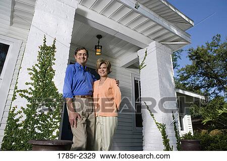 Portrait of a mature couple standing outside a house View Large Photo Image Stock Photo - Portrait of a mature couple standing outside a house. Fotosearch
