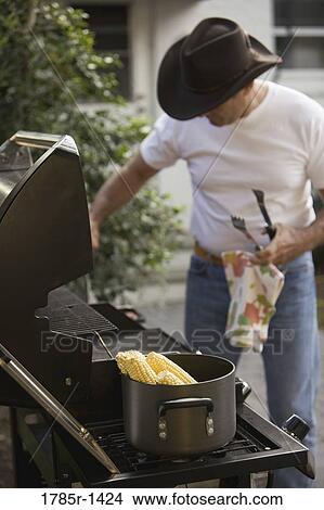 Portrait of a mature man preparing corn on grill View Large Photo Image Picture - Portrait of a mature man preparing corn on grill. Fotosearch