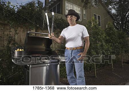 Stock Photo - Portrait of a mature man preparing grill steak. Fotosearch