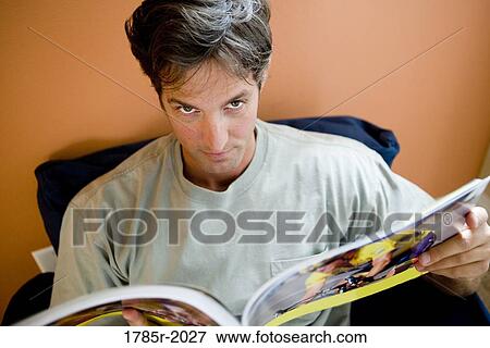 Portrait of a mid adult man looking up from reading a book View Large Photo Image Stock Photo - Portrait of a mid adult man looking up from reading a book. Fotosearch