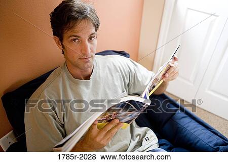 Stock Photo - Portrait of a mid adult man reading a book. Fotosearch