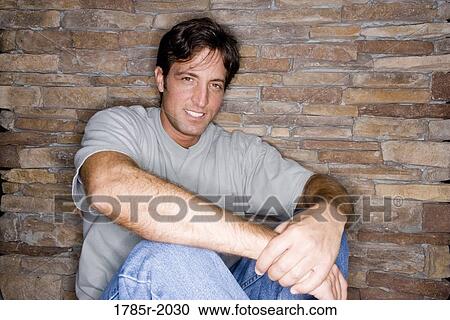 Portrait of a mid adult man sitting against a stone wall View Large Photo Image Stock Image - Portrait of a mid adult man sitting against a stone wall. Fotosearch