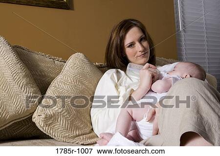Stock Photo - Portrait of a mother feeding infant with a bottle. Fotosearch