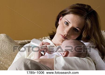 Portrait of a mother feeding infant with a bottle View Large Photo Image Stock Photograph - Portrait of a mother feeding infant with a bottle. Fotosearch
