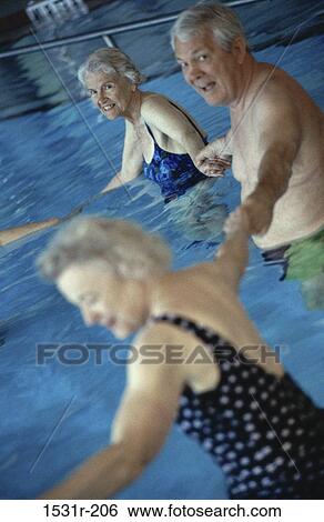 Portrait of a senior man holding hands with two senior women in a swimming pool View Large Photo Image Stock Photograph - Portrait of a senior man holding hands with two senior women in a swimming pool. Fotosearch