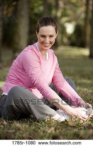 Portrait of a smiling young woman exercising and stretching in a park View Large Photo Image Stock Image - Portrait of a smiling young woman exercising and stretching in a park. Fotosearch