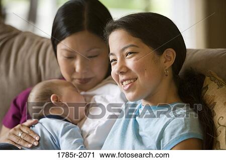 Portrait of a teenage Asian-Caucasian girl with mother holding baby brother View Large Photo Image Stock Image - Portrait of a teenage Asian-Caucasian girl with mother holding baby brother. Fotosearch