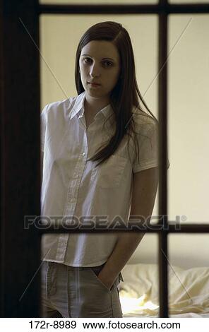 Portrait of a teenage girl looking through a window View Large Photo Image Stock Photo - Portrait of a teenage girl looking through a window. Fotosearch