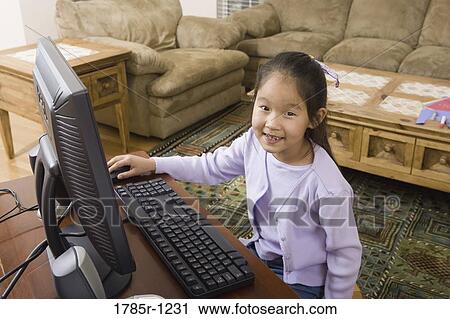 Portrait of a young Asian girl using computer View Large Photo Image Stock Image - Portrait of a young Asian girl using computer. Fotosearch