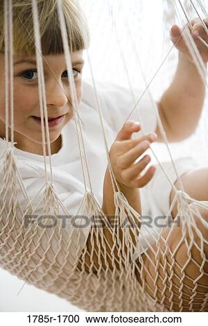 Portrait of a young boy sitting in a hammock View Large Photo Image Stock Image - Portrait of a young boy sitting in a hammock. Fotosearch