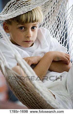 Portrait of a young boy sitting in a hammock View Large Photo Image Stock Photo - Portrait of a young boy sitting in a hammock. Fotosearch