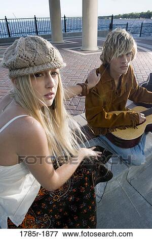 Portrait of a young couple in vintage 1960's costumes in a park, playing a guitar View Large Photo Image Stock Photo - Portrait of a young couple in vintage 1960's costumes in a park, playing a guitar. Fotosearch