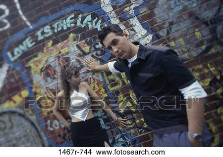 Picture - Portrait of a young couple near a graffiti covered wall. Fotosearch