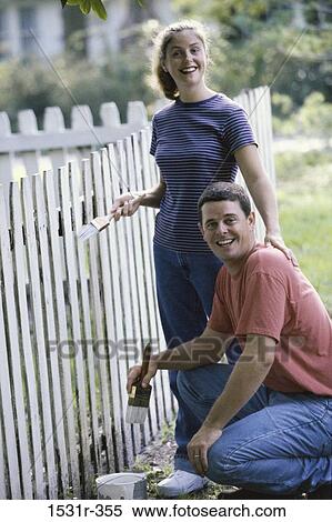 Portrait of a young couple painting a fence View Large Photo Image Stock Photography - Portrait of a young couple painting a fence. Fotosearch