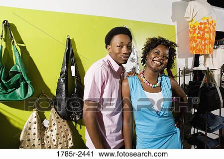 Stock Image - Portrait of a young couple standing in a boutique. Fotosearch