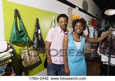 Portrait of a young couple standing in a boutique View Large Photo Image Stock Image - Portrait of a young couple standing in a boutique. Fotosearch