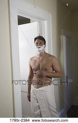 Portrait of a young man shaving wearing a towel View Large Photo Image Picture - Portrait of a young man shaving wearing a towel. Fotosearch