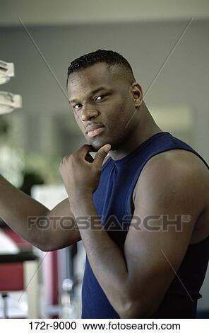 Stock Image - Portrait of a young man touching his chin. Fotosearch