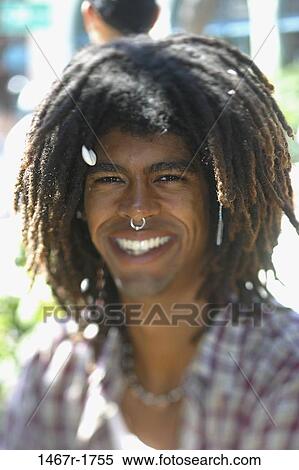 Stock Photography - Portrait of a young man wearing a nose ring smiling. Fotosearch