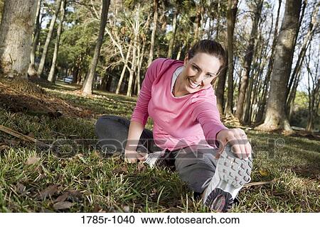 Portrait of a young woman exercising and stretching in a park View Large Photo Image Stock Image - Portrait of a young woman exercising and stretching in a park. Fotosearch