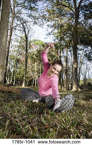 Portrait of a young woman exercising and stretching in a park View Large Photo Image Stock Image - Portrait of a young woman exercising and stretching in a park. Fotosearch