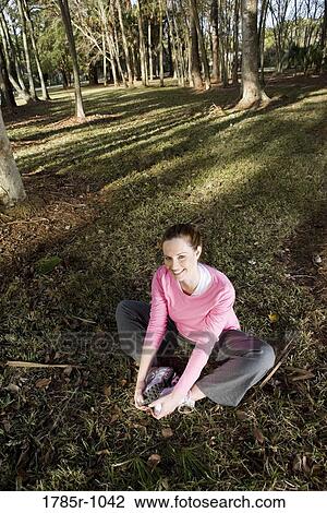 Portrait of a young woman exercising and stretching in a park View Large Photo Image Stock Image - Portrait of a young woman exercising and stretching in a park. Fotosearch