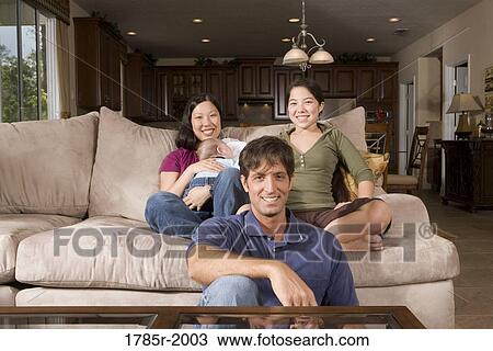 Portrait of an Asian-Caucasian family sitting on sofa and the floor View Large Photo Image Stock Image - Portrait of an Asian-Caucasian family sitting on sofa and the floor. Fotosearch