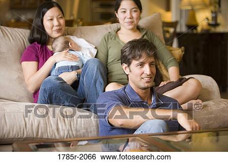 Portrait of an Asian-Caucasian family sitting on sofa and the floor View Large Photo Image Stock Photograph - Portrait of an Asian-Caucasian family sitting on sofa and the floor. Fotosearch