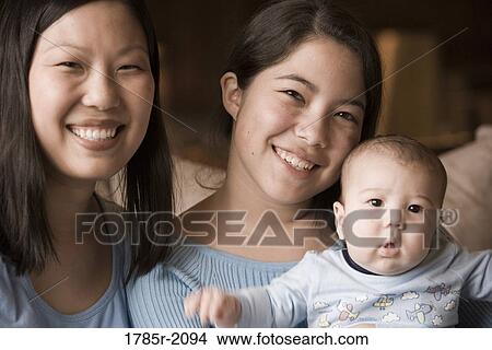Picture - Portrait of an Asian mother with her Asian-Caucasian teenage daughter and infant boy. Fotosearch