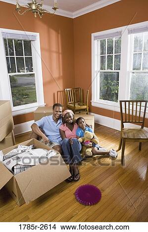 Picture - Portrait of family sitting by moving boxes. Fotosearch