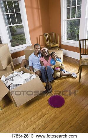 Portrait of family sitting by moving boxes View Large Photo Image Stock Image - Portrait of family sitting by moving boxes. Fotosearch