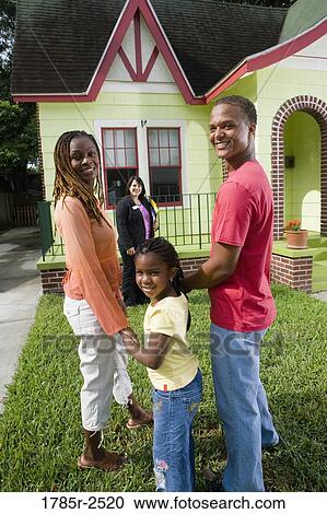 Portrait of family standing outside house with real estate broker View Large Photo Image Stock Image - Portrait of family standing outside house with real estate broker. Fotosearch