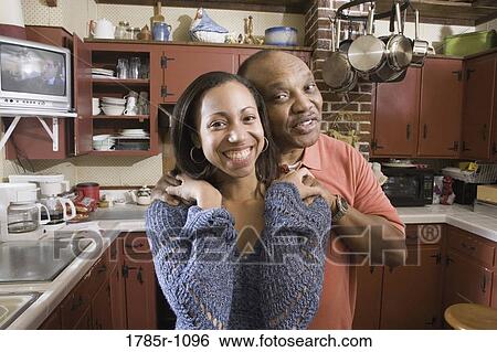Stock Photograph - Portrait of father and daughter in kitchen. Fotosearch