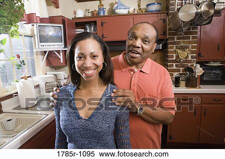 Stock Photography - Portrait of father and daughter in kitchen. Fotosearch
