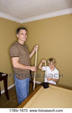 Portrait of father and son chalking cue sticks by pool table View Large Photo Image Stock Image - Portrait of father and son chalking cue sticks by pool table. Fotosearch