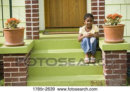 Portrait of girl sitting on steps outside house View Large Photo Image Stock Photo - Portrait of girl sitting on steps outside house. Fotosearch