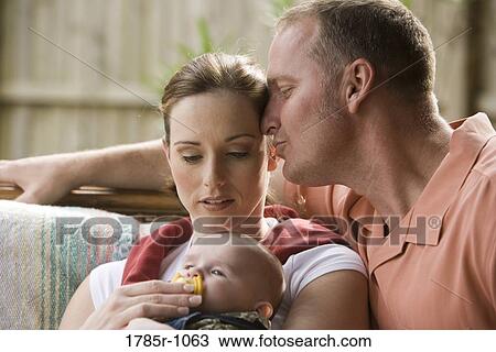 Stock Image - Portrait of loving parents with baby outdoors. Fotosearch
