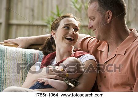 Portrait of smiling parents with baby outdoors View Large Photo Image Picture - Portrait of smiling parents with baby outdoors. Fotosearch