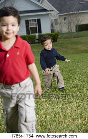 Portrait of two boys playing on lawn View Large Photo Image Picture - Portrait of two boys playing on lawn. Fotosearch