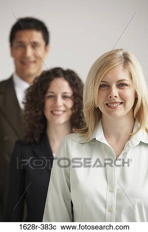 Portrait of two businesswomen and a businessman smiling View Large Photo Image Stock Image - Portrait of two businesswomen and a businessman smiling. Fotosearch